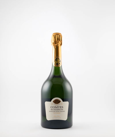 A bottle of 2013 Taittinger Comtes De Champagne with a label and a golden foil cap, against a white background.